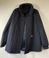 Front view of the black quilted Betsey Johnson jacket with collar, heart-shaped quilted design and button closure.