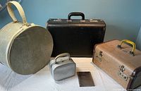 Group view of all luggage items and accessories placed on a white cloth against a blue wall.