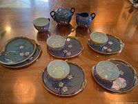 Full set displaying 6 plates, 4 teacups on plates, blue pitcher, sugar dish, and one additional blue teacup