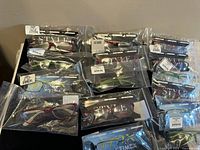 Fifteen pairs of optical eyewear frames in original unopened packaging from Timex and Style brands arranged on a surface.