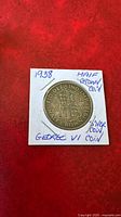 Close-up image of the 1938 George VI Half Crown silver coin in a protective paper holder with handwritten notes.