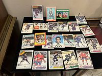 Photo showing all 23 hockey cards spread on a table, displaying various players and team editions from 1972/73 through 1977/78 seasons.
