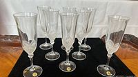 Front view of eight clear crystal champagne flutes arranged in rows