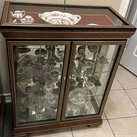 Front-side view of the wooden display cabinet with glass doors showing dishes inside