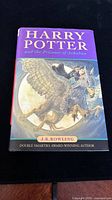 Front cover of Harry Potter and the Prisoner of Azkaban first edition book with purple dust jacket featuring a flying creature illustration.
