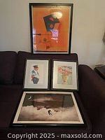 Three framed posters displayed together: large abstract geometric poster, smaller man in uniform, and floral bouquet poster