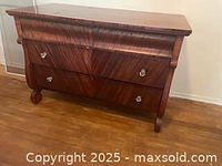 Front angled view of vintage mahogany dresser showing wood grain and two drawers with metal ring pull handles.