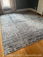Full view of the polyester rug spread on a wooden floor beneath a window, showing size and pattern
