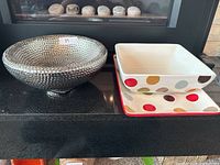 Overall set display including silver bowl and two polka dot ceramic platters.