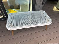 Top view of the rectangular glass patio table showing the glass surface and ribbed frame.