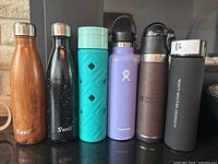 Photo showing full lineup of six assorted water bottles with various colors and brands
