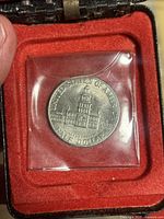 Reverse side of 1976 Kennedy half dollar coin showing Independence Hall and related inscriptions.