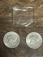 Photo of reverse side of two 1976 US Bicentennial Eisenhower Dollar coins showing Liberty Bell and denomination