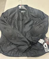 Front view of the black Z1R motorcycle jacket with visible elbow padding and textured mesh fabric.