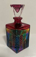 Front and side views of Murano perfume bottle showing multicolor geometric pattern and faceted stopper.