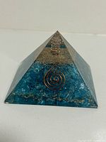 Front angle view showing the pyramid shape, blue quartz chips inside and copper coil design.