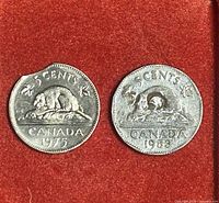 Both 1953 and 1975 Canadian 5 cent coins showing mint errors and condition on red felt.