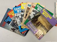 Collection of 10 Canadian West magazines fanned out showing variety of colorful and black/white covers depicting historical Western scenes.