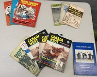 Various vintage magazines spread on a table, featuring Canada West, British Columbia Ghost Town Atlas, Cariboo Digest, Gold Assay & Miners Journal, and others.