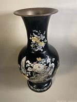 Full front view showing black lacquer body with mother of pearl floral and bird decorations and flared rim.