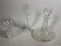 Full view of set showing decanter with stopper, champagne flute, and two small vases