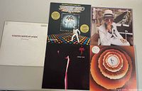 Five vintage classic rock and disco double LP vinyl record albums arranged in a group showing front cover artwork including Bee Gees, Elton John, Steely Dan, Stevie Wonder and Earth Wind & Fire.