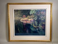 Front view of framed oil painting depicting a pond with foliage and reflections