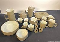 Photo showing full lot with all dishware pieces including pitchers, mugs, teapot, covered serving dish, gravy boat and eggs cups arrayed on table.