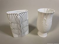 Two vases side by side: a white Rosenthal vase with gray linear design and a white Kaiser bisque vase with embossed floral pattern