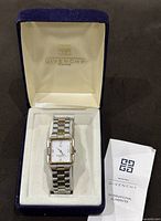 Givenchy watch in original branded box with certificate folded beside it.