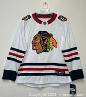 Front view of the white Chicago Blackhawks NHL jersey by Fanatics, showing embroidered team logo and shoulder patches with red, black, and white striping.