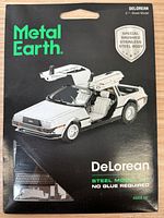 Front view of the Metal Earth Delorean model kit packaging showing the assembled model with open gull-wing doors and special brushed stainless steel body.