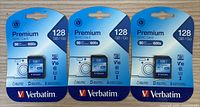 Three Verbatim Premium SDXC 128 GB cards in retail packaging shown from the front