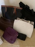 Group of five main handbags arranged on floor