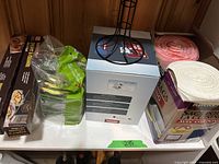 Overview shelf with garbage bags, vacuum bags, kitchen scrubbies, parchment paper, and egg dispenser stand.