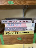 Four books stacked on wooden shelf