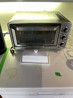 Cuisinart toaster oven on countertop alongside a white ceramic butter dish with lid.