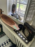 Overview of wooden dough bowl, metal planter, tea light holder, and art block on radiator cover