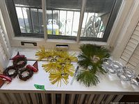 Full lot of candle holders and napkin rings arranged on white surface near window.