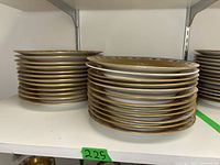 Two stacks of German china plates showing 12 flat plates and 12 dip plates with gold and floral decoration