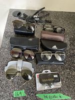 Eyewear including seven pairs of men’s sunglasses and glasses with cases and clip-on readers