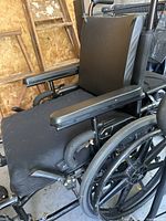 Close-up side view of wheelchair showing padded seat and armrests.