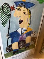 Close-up of the poster showing a cubist figure with a butterfly net and a flower, with 'Picasso' written on the hat.