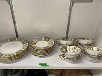 Full lot view showing stacks of medium and small plates with cups on right