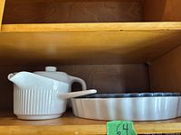 Photo showing white ceramic cream and sugar bowl with lid and spoon alongside large ceramic tray with fluted edges.