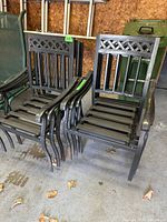 Group of six black iron chairs stacked and lined up in garage setting