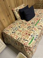 Photo showing trundle bed with floral pattern fabric bed skirt and pillows on top of mattress.