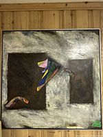 Front view of square abstract painting with two dark rectangles and colorful accents in frame