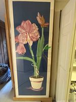 Full front view of framed botanical print showing pink amaryllis, wood frame, glass and white mat.