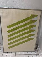 Front view of framed abstract geometric art showing six green diagonal stripes and faint grid background